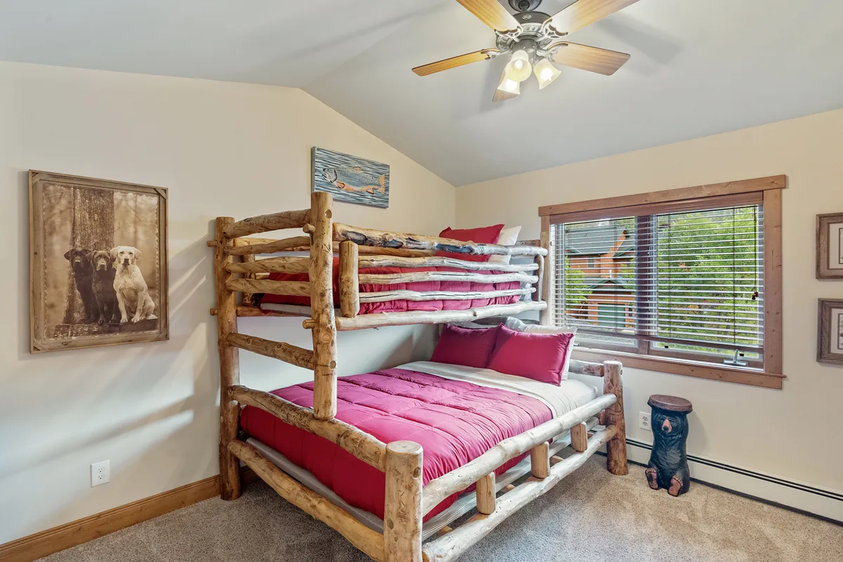 The third bedroom is captured here with a twin-over-queen bunk bed, playful décor, and sunlight streaming through a window. The room feels lively and adaptable, perfect for children or flexible sleeping arrangements.